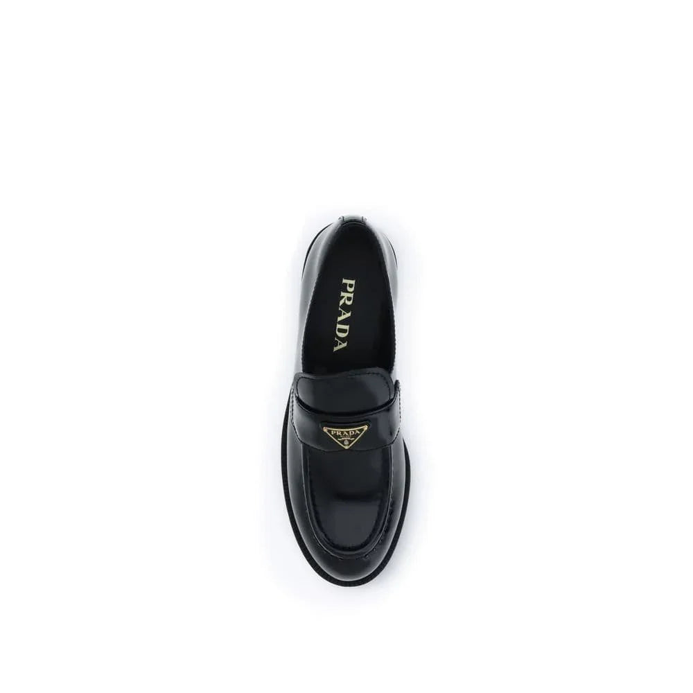 Black leather loafer with gold Prada logo detail, luxury designer footwear