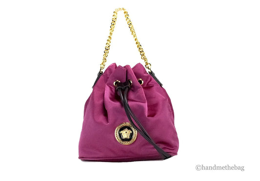 Purple drawstring designer bucket bag with gold chain strap and medallion emblem